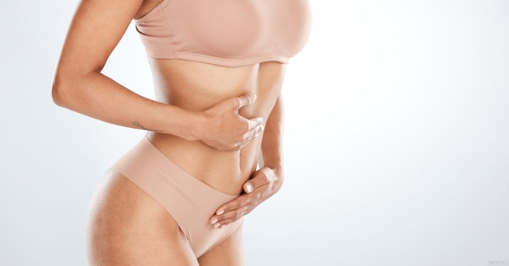 Woman with their hands on their stomach (model)