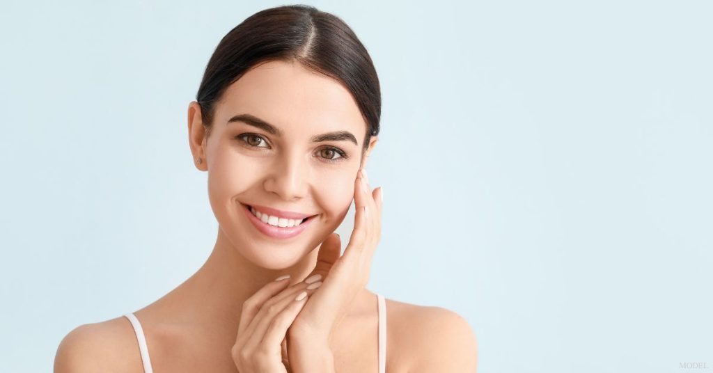 Smiling woman touching her cheek (model)